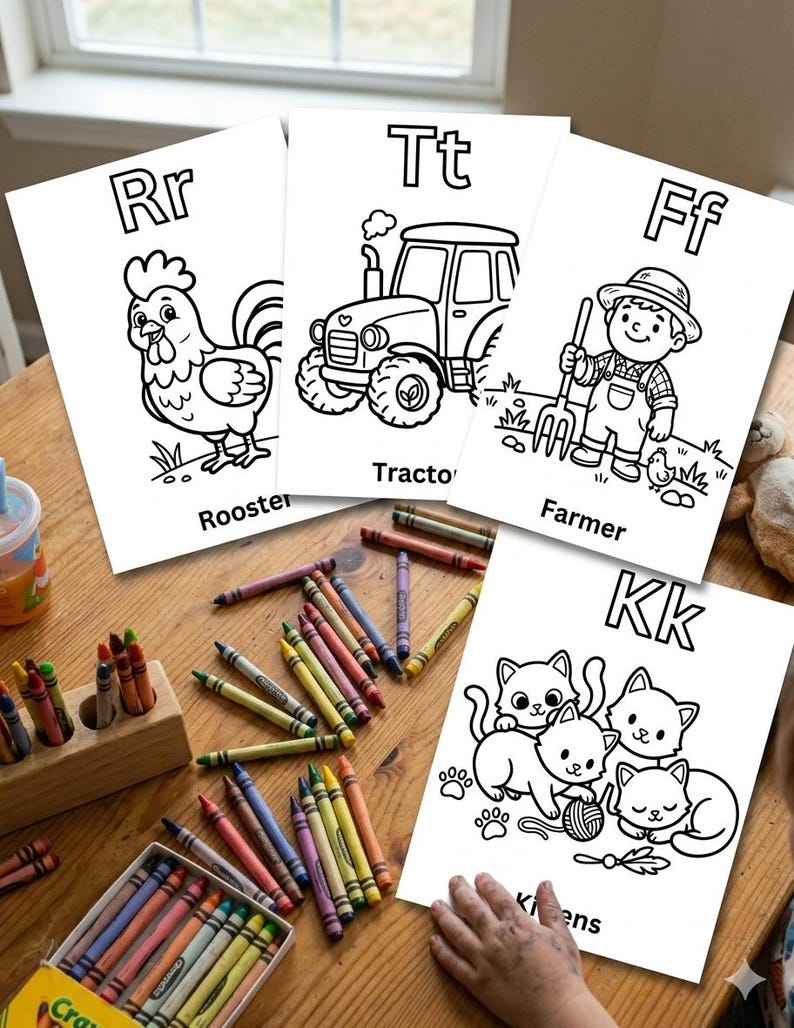 Puede incluir: Cuatro p&aacute;ginas para colorear blancas con ilustraciones de l&iacute;neas negras de un gallo, un tractor, un granjero y gatitos, cada una etiquetada con su letra y nombre. Una caja de madera llena de crayones de cera de colores est&aacute; cerca.