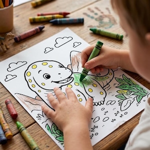May include: A white coloring page featuring a cartoon dinosaur with spots, clouds, and foliage. The dinosaur is partially colored in green and brown. Several wax crayons in various colors are scattered around the paper on a wooden surface.