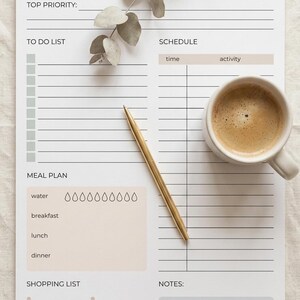 May include: A daily planner sheet with sections for top priority, to do list, schedule, meal plan with water intake icons, shopping list, and notes. The planner features black text on a white background with beige and gray accents, a gold pen, and a coffee mug.