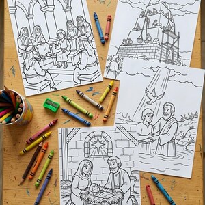 May include: Four black and white coloring pages depicting religious scenes, including a nativity, baptism, and a group of people in a building. Colored crayons and pencils are scattered around the pages on a wooden surface.