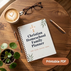 May include: A spiral-bound Christian Homeschool Family Planner with a white cover featuring a cross illustration, green leaf accents, and the text: Christian Homeschool Family Planner, Faith - Family - Learning - Legacy. Includes a pen and glasses.
