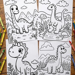 May include: Four black and white dinosaur colouring pages on a wooden surface. Each page features a different dinosaur illustration with a landscape background, including mountains, clouds, and vegetation. Crayons are visible around the pages.