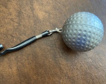 Golf ball shaped golf bag attachment