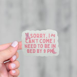 May include: A white sticker with pink glitter and a pink cartoon bear. The sticker says "Sorry, I can't come I need to be in bed by 9 PM".