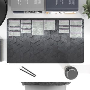 Puede incluir: Una alfombrilla de escritorio gris y negra con un patrón geométrico de triángulos. La alfombrilla tiene una cuadrícula de 12 cuadrados con texto y números en cada cuadrado. El texto es gris claro y los números son negros.