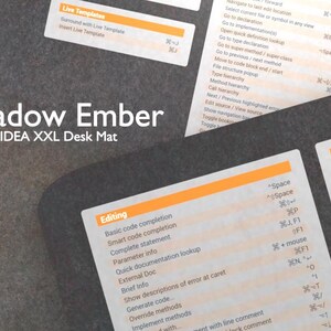 Peut inclure: Un tapis de bureau noir et orange avec le texte "Shadow Ember" et "IntelliJ IDEA XXL Desk Mat" imprimé dessus. Le tapis présente une liste de raccourcis clavier et de commandes pour le logiciel IntelliJ IDEA, organisés par catégorie, telles que "Édition", "Modèles en direct" et "Se souvenir de".