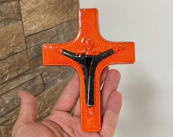 May include: Orange ceramic wall cross with a black figure of Jesus Christ.