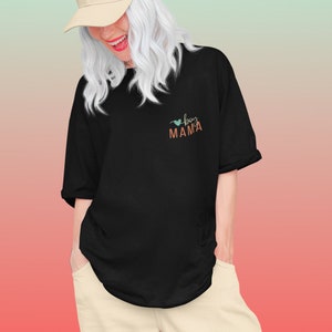 Pode incluir: Uma camiseta preta com um coração e o texto "boy mama" em laranja e turquesa.