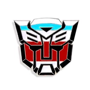 Könnte beinhalten: Eine schwarze, weiße, rote und blaue Emaille-Anstecknadel mit dem Autobot-Symbol. Das Symbol ist ein stilisierter Roboterkopf mit schwarzem Umriss und weißem Hintergrund. Die Oberseite des Symbols ist rot, weiß und blau.