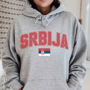 May include: Gray hooded sweatshirt with the word "SRBIJA" in red letters and the Serbian flag printed below.