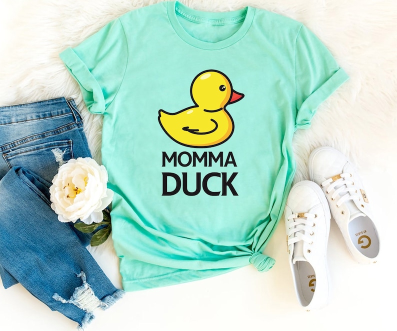May include: A turquoise t-shirt with a yellow rubber duck illustration and the text "Momma Duck" in black.