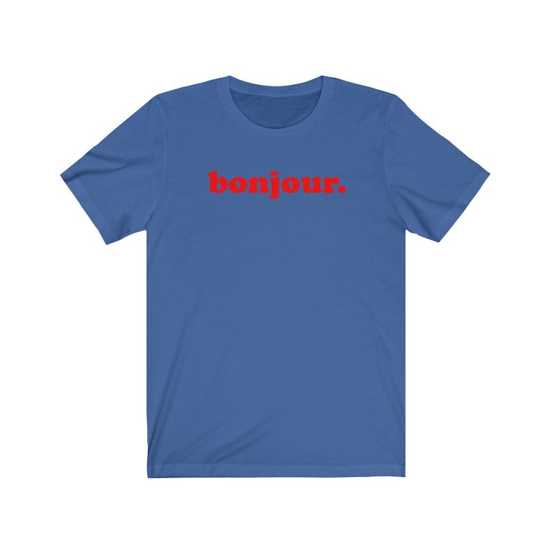 Pode incluir: Uma camiseta azul royal com a palavra "bonjour" impressa em vermelho.
