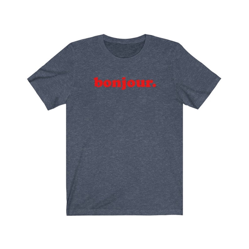 Pode incluir: Uma camiseta azul escura com a palavra "bonjour" impressa em vermelho na frente.