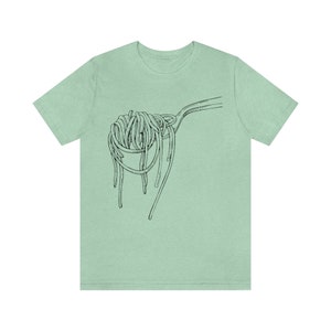 Op de afbeelding: Een lichtgroen t-shirt met een zwart-witte illustratie van een vork met spaghetti erop.