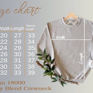 May include: A light gray Gildan 18000 Heavy Blend Crewneck sweatshirt displayed on a wooden hanger. The image includes a size chart with measurements in inches for width, length, and sleeve length, ranging from size S to 4XL.