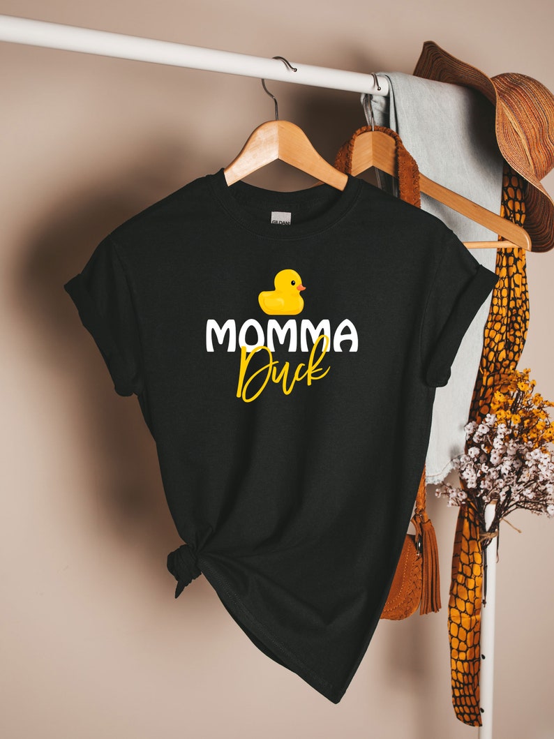 May include: Black t-shirt with a yellow rubber duck and the text "Momma Duck" in white.