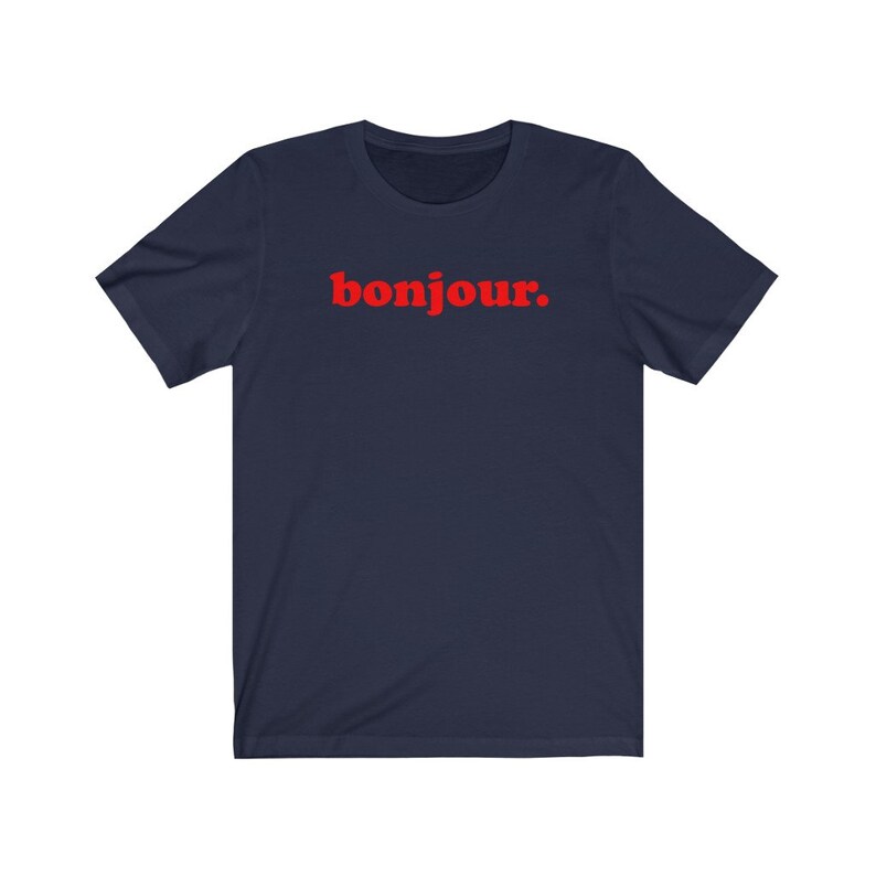 Pode incluir: Uma camiseta azul marinho com a palavra "bonjour" impressa em vermelho na frente.