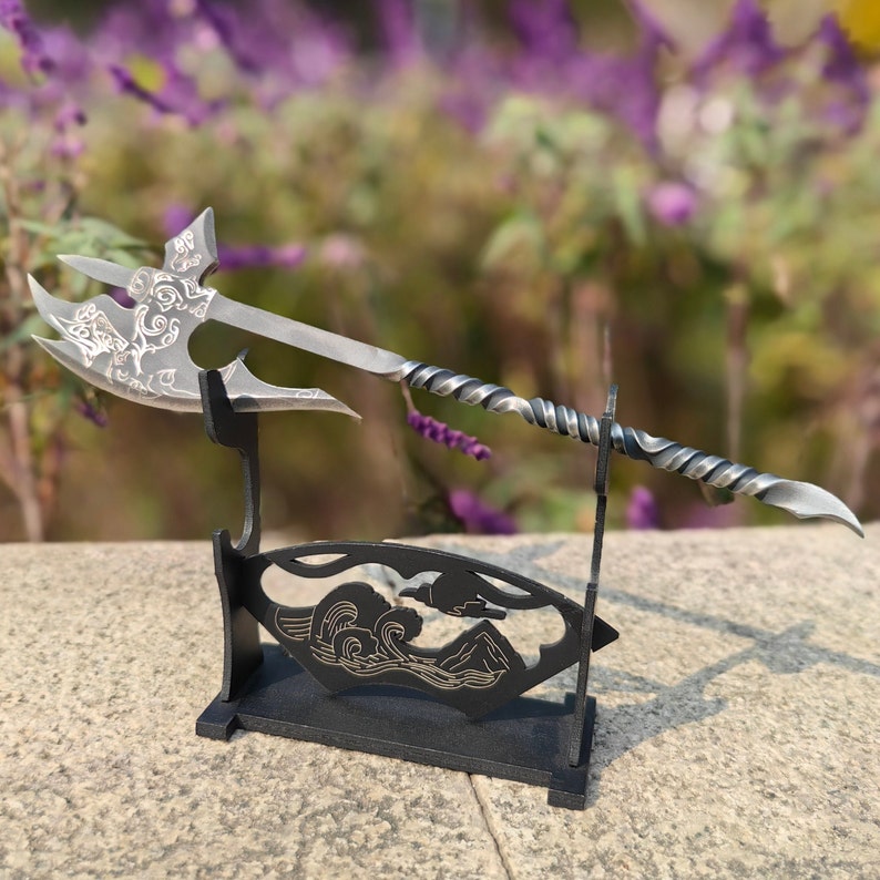 May include: A silver axe with a twisted handle and intricate designs on the blade is displayed on a black stand with a wave design.