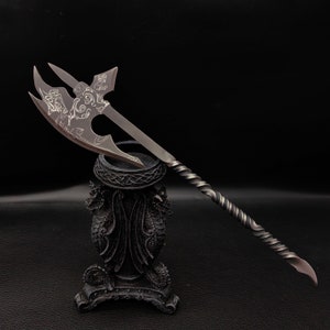 May include: A silver axe with a twisted handle and intricate etched designs on the blade, displayed on a black dragon-shaped stand.