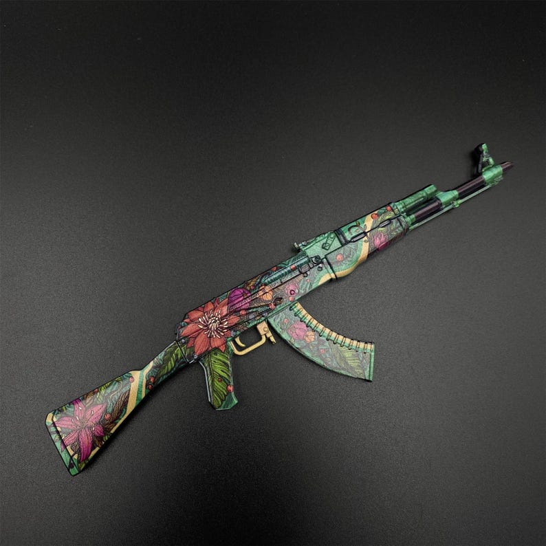 Puede incluir: Un rifle estilo AK-47 con un dise&ntilde;o floral. El rifle presenta un patr&oacute;n floral verde, beige y morado. El cargador y el ca&ntilde;&oacute;n son verdes y negros. El fondo es gris oscuro.
