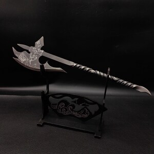 May include: A black metal axe with a twisted handle and intricate designs on the blade. The axe is displayed on a black stand with a wave design.