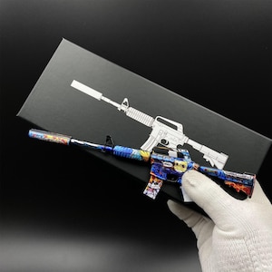 Pu&ograve; includere: Un fucile giocattolo colorato con un design vibrante, con sfumature di blu, arancione e giallo. Il fucile &egrave; tenuto contro uno sfondo nero con un contorno bianco di un fucile simile. Il design include un personaggio dei cartoni animati.