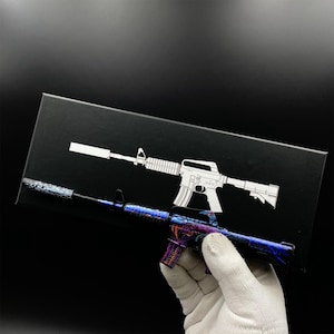 Pu&ograve; includere: Un modello dettagliato di fucile d'assalto con silenziatore, con un design blu, viola e arancione. Un contorno bianco del fucile &egrave; su uno sfondo nero.