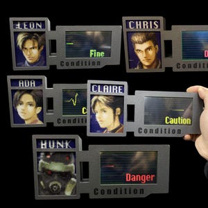 Może przedstawiać: Zestaw szarych, prostokątnych rekwizytów w stylu przenośnych konsol do gier, z portretami postaci i słowami "Condition" oraz "Fine", "Caution" i "Danger". Rekwizyty mają imiona postaci takie jak "Leon", "Chris", "Ada", "Claire" i "Hunk".