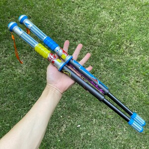 May include: Two toy light sabers with blue, yellow, and silver accents. The handles have colorful designs and the blades are clear with blue lights. Each saber has a wrist strap.
