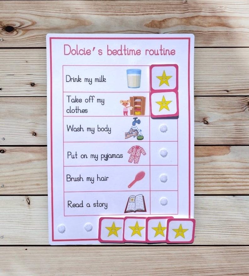 May include: A pink and white bedtime routine chart with the text "Dolcie's bedtime routine." The chart includes illustrations and text for each step, such as drinking milk, taking off clothes, and reading a story. The chart has star-shaped reward stickers.