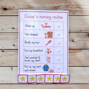 May include: A pink and white morning routine chart with the text "Dolcie's morning routine." The chart includes illustrations for each step, such as "Wake up," "Get dressed," and "Eat my breakfast." There are star stickers at the bottom.