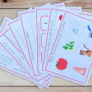 Op de afbeelding: Een set met printbare educatieve werkbladen voor kinderen. De werkbladen bevatten kleurrijke illustraties van dieren, voorwerpen en letters. De tekst op de werkbladen is "Practise writing the letters", "Cut these letters out to use with the activities", "Find out the letters to spell the words", and "Match the phonic sound with the picture".
