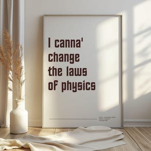 Peut inclure: Impression d'art encadrée avec la citation "I canna' change the laws of physics" en marron. L'impression est dans un cadre argenté et est posée contre un mur blanc. Un vase avec des plantes séchées et un tissu drapé sont au premier plan.