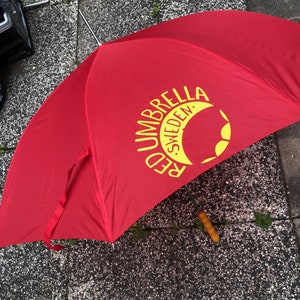 Roter Regenschirm mit Schriftzug für RUS. Traditionelles langes Modell, 86 cm, gefaltet.
