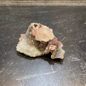May include: A small, rough, white and purple crystal cluster with a natural, irregular shape.