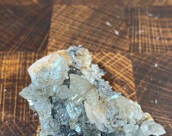 May include: A cluster of white and clear barite crystals with a silvery gray metallic base. The crystals are sharp and have a glassy luster.