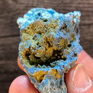 May include: A blue and green crystal cluster with a rough, textured surface. The crystal has a unique, organic shape and is a beautiful example of natural beauty.