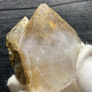 以下が含まれることがあります： 二重の終端を持つ、大きな透明な水晶。水晶は薄い茶色で、ほとんど金色で、小さな輝く内包物がたくさんあります。