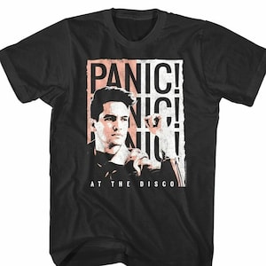 May include: Black t-shirt with a graphic of a man with the text "Panic! At The Disco" in pink and white.