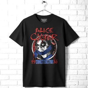 May include: A black short-sleeve t-shirt featuring a graphic of Alice Cooper with a blue snake wrapped around the face. The text reads Alice Cooper and 19 Constrictor 86 in red and blue. The shirt has a crew neckline and a standard fit.