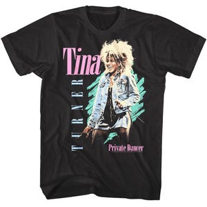 May include: Black t-shirt featuring a graphic of Tina Turner in a denim jacket and a short skirt. The text "Tina Turner" is in pink and white, with "Private Dancer" in white below the image.