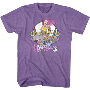 May include: Purple t-shirt featuring a colorful graphic of a woman with pink hair riding a bomb-shaped shark. The graphic is surrounded by a circular design with the word "Incubus" in a stylized font.