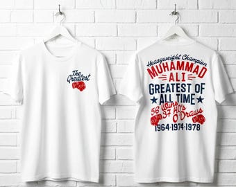 Op de afbeelding: Een wit t-shirt met een kleine rode bokshandschoenafbeelding en de tekst The Greatest op de voorkant. De achterkant toont de tekst Heavyweight Champion Muhammad Ali Greatest of All Time, 56 Wins, 37 KO's, 0 Draws en 1964-1974-1978.