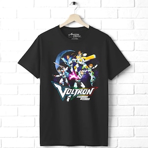 May include: A black short-sleeve t-shirt featuring a graphic print of five characters in futuristic armor against a space background. Below the characters, the text reads Voltron Legendary Defender in white, blue, red, and green lettering.