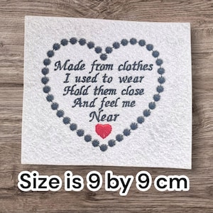 May include: A white square with embroidered text and a heart-shaped border. The text reads "Made from clothes I used to wear, Hold them close, And feel me Near." A red heart is at the bottom. The size is 9 by 9 cm.