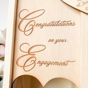 May include: Wooden box with a heart-shaped opening and the text "Congratulations on your engagement".