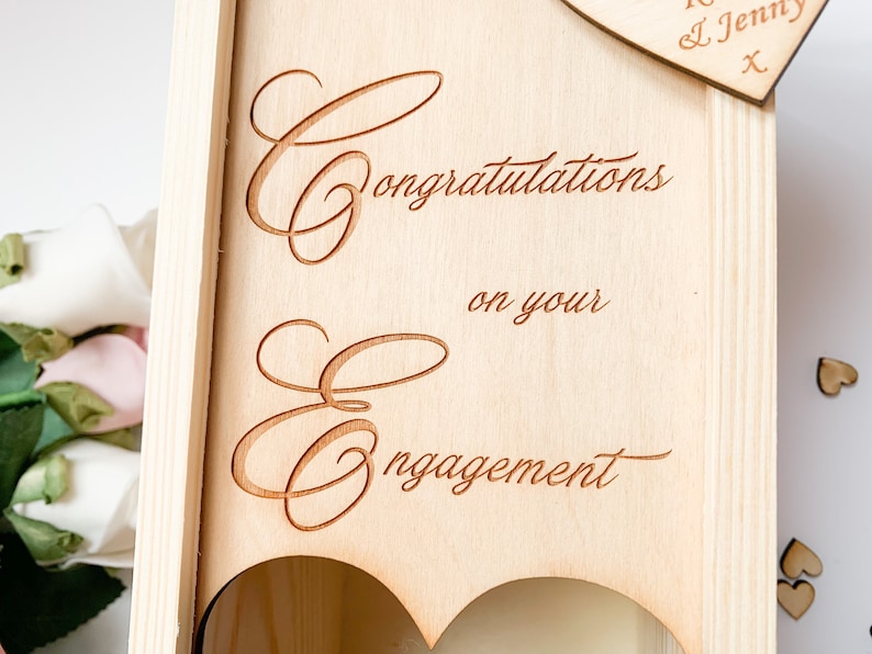 May include: Wooden box with a heart-shaped opening and the text "Congratulations on your engagement".