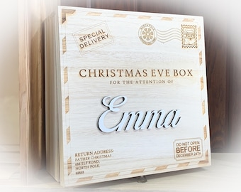 May include: A wooden Christmas Eve box with a personalized name "Emina" and the text "SPECIAL DELIVERY", "CHRISTMAS EVE BOX", "FOR THE ATTENTION OF", "RETURN ADDRESS: FATHER CHRISTMAS, 688 ELF ROAD, NORTH POLE 88838", and "DO NOT OPEN BEFORE DECEMBER 24TH".