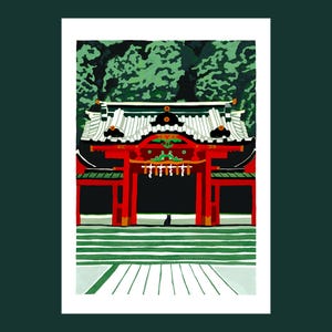 May include: A red and black Japanese temple gate with a green roof and a black cat sitting in front of it. The gate is surrounded by green trees and a white stone path.