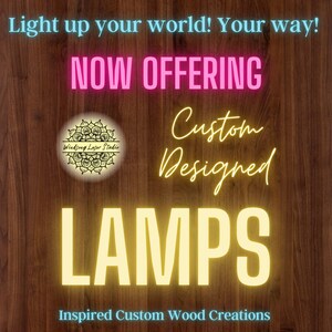 May include: A wooden sign with the text "Light up your world! Your way!" in blue text. The text "NOW OFFERING" is in pink text. The text "Custom Designed LAMPS" is in yellow text. The text "Inspired Custom Wood Creations" is in blue text. A logo for "Windsong Laser Studio" is in the center of the sign.